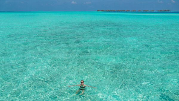 Swimming in the Indian Ocean with Overwater Bungalows in Background